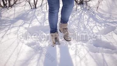 一个年轻女孩跳起来保暖的腿。 那个女人在一个白雪覆盖的冬季公园里冻僵了。 特写镜头。
